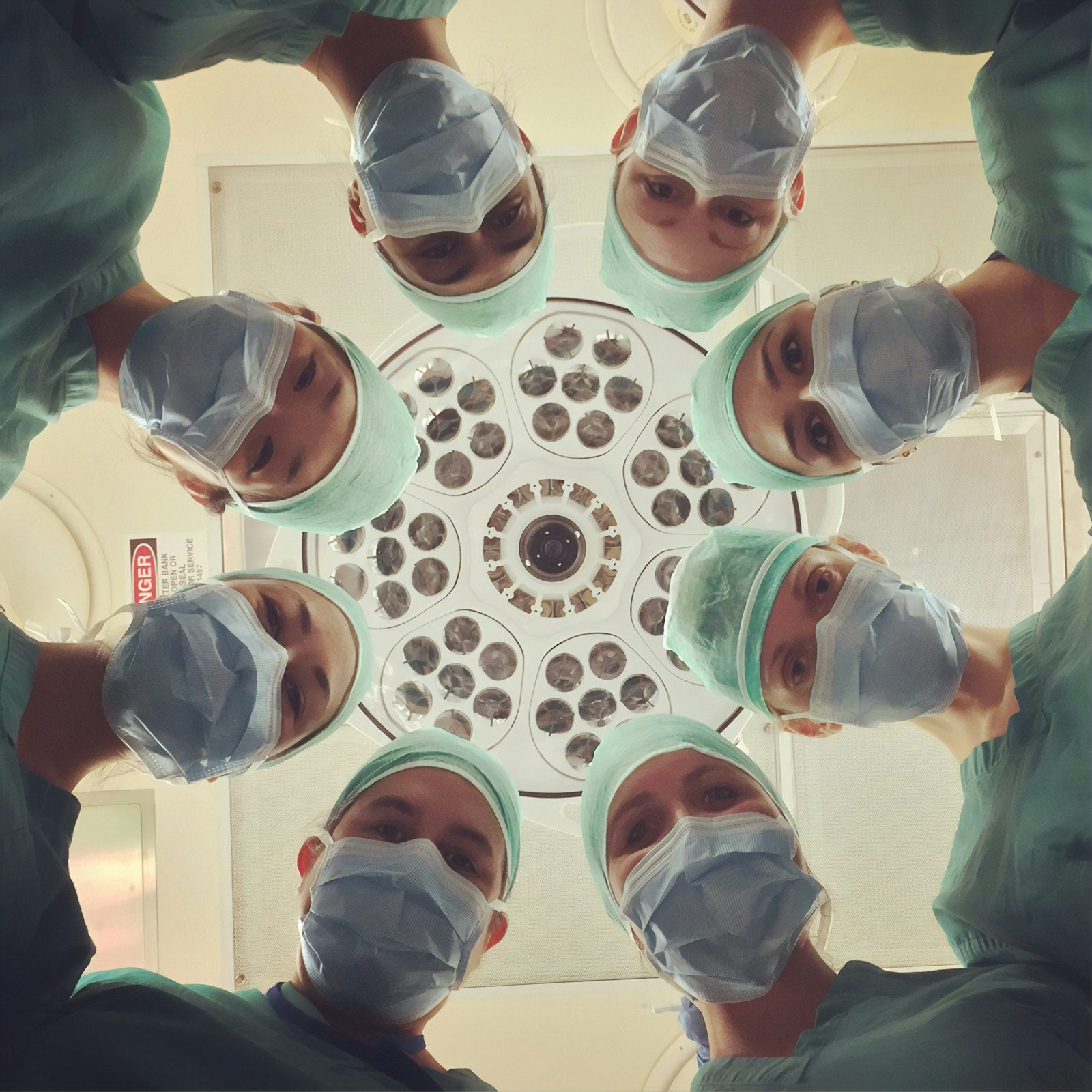 A surgical team gathered around an operating light